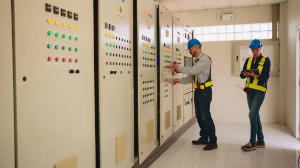 two electrical engineer working in control room at industry factory.